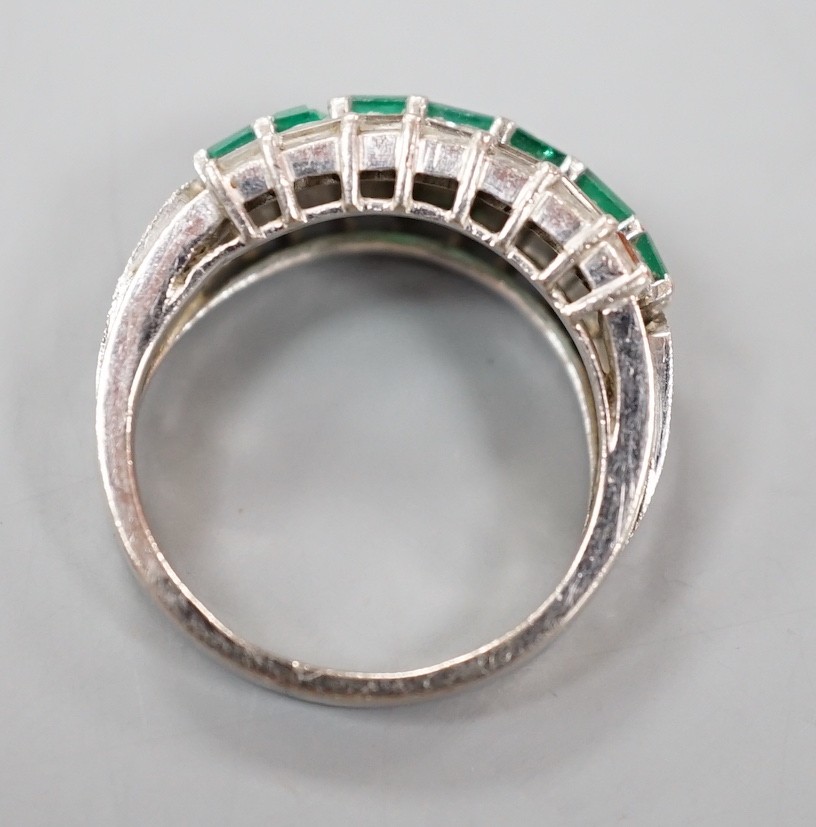 A modern 18k white metal, emerald and baguette cut diamond set three row half hoop ring (shank cut), size L, gross weight 5 grams.
